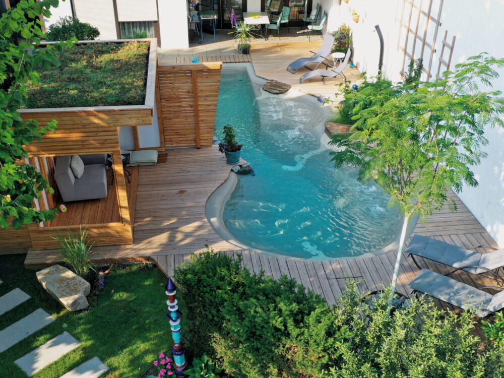 BIO.design Pool Luftaufnahme mit Holzdeck und überdachter Sitzecke aus Holz