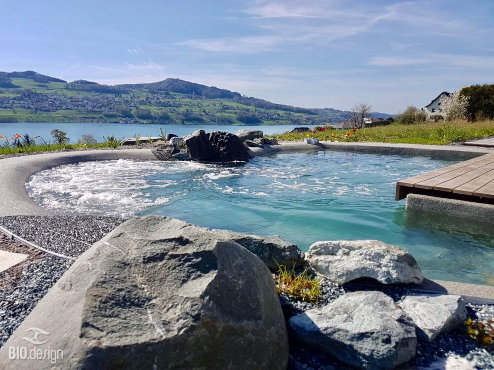 BIO.design Pool mit Steinen im Vordergrund und Landschaft hinten